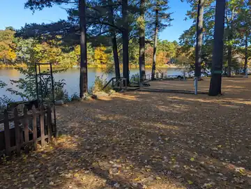 Wooded lakefront campsite 105 with elevated scenic views of Swains Lake and autumn foliage